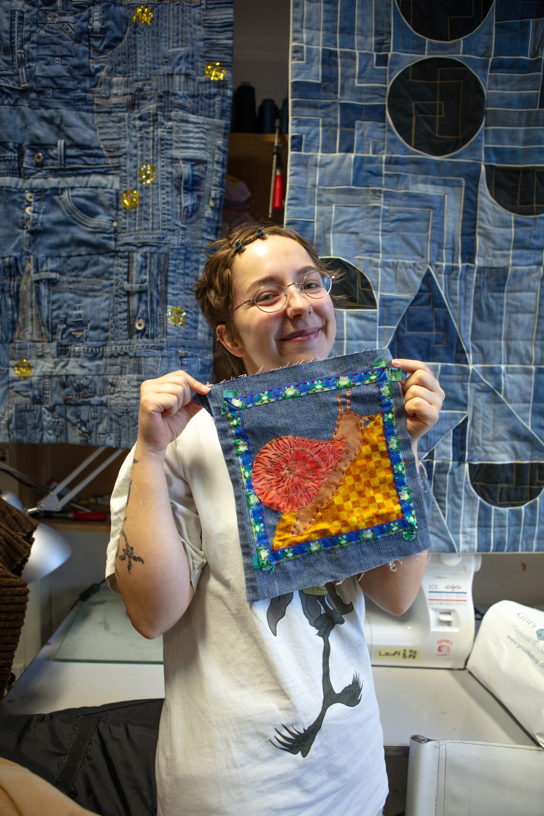A participant holding up a finished free square with a hand-appliqued heart.