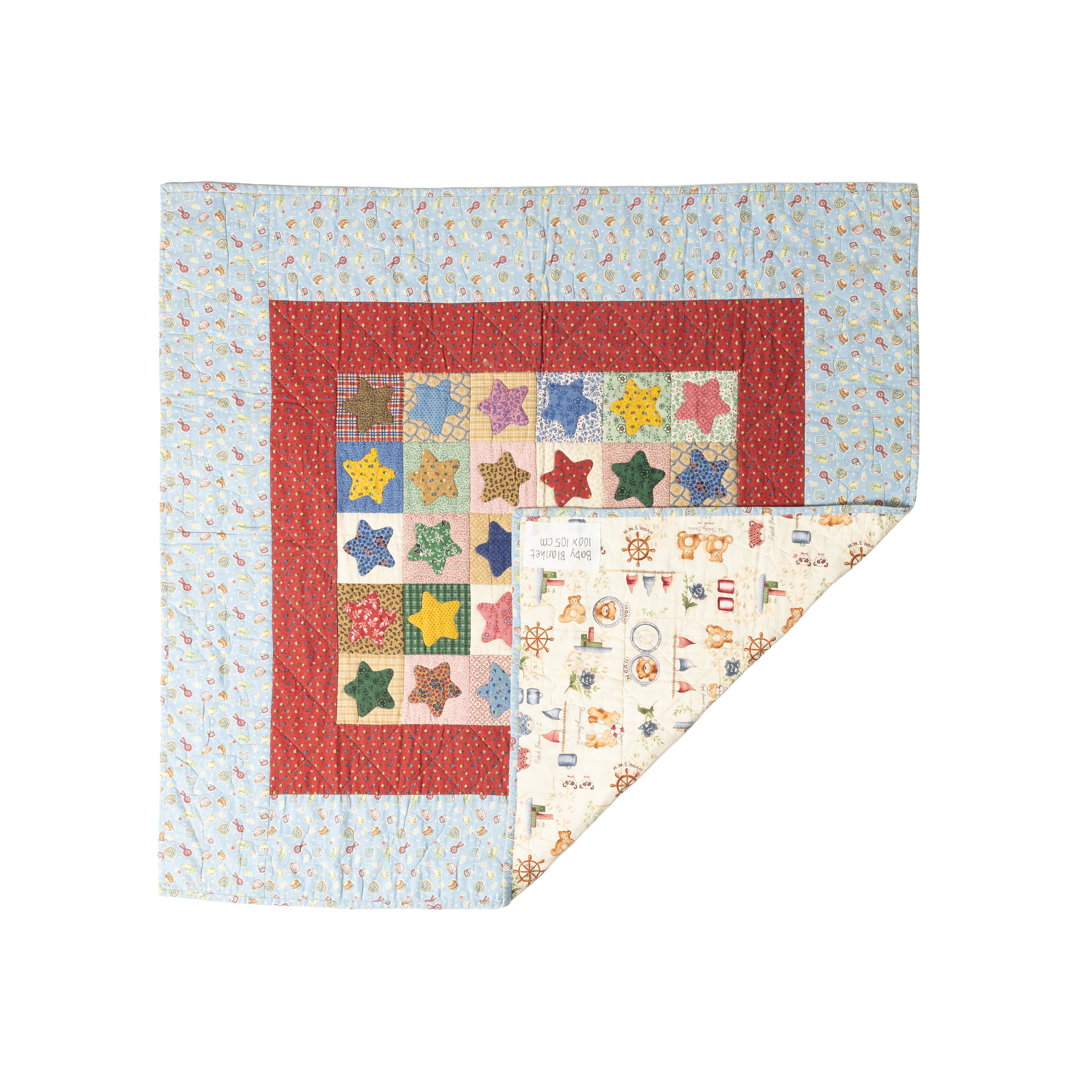 Baby Blanket, a quilt with an appliquéd star patchwork center framed by a red border and floral fabric, backing corner folded open to reveal a nautical teddy-bear print.