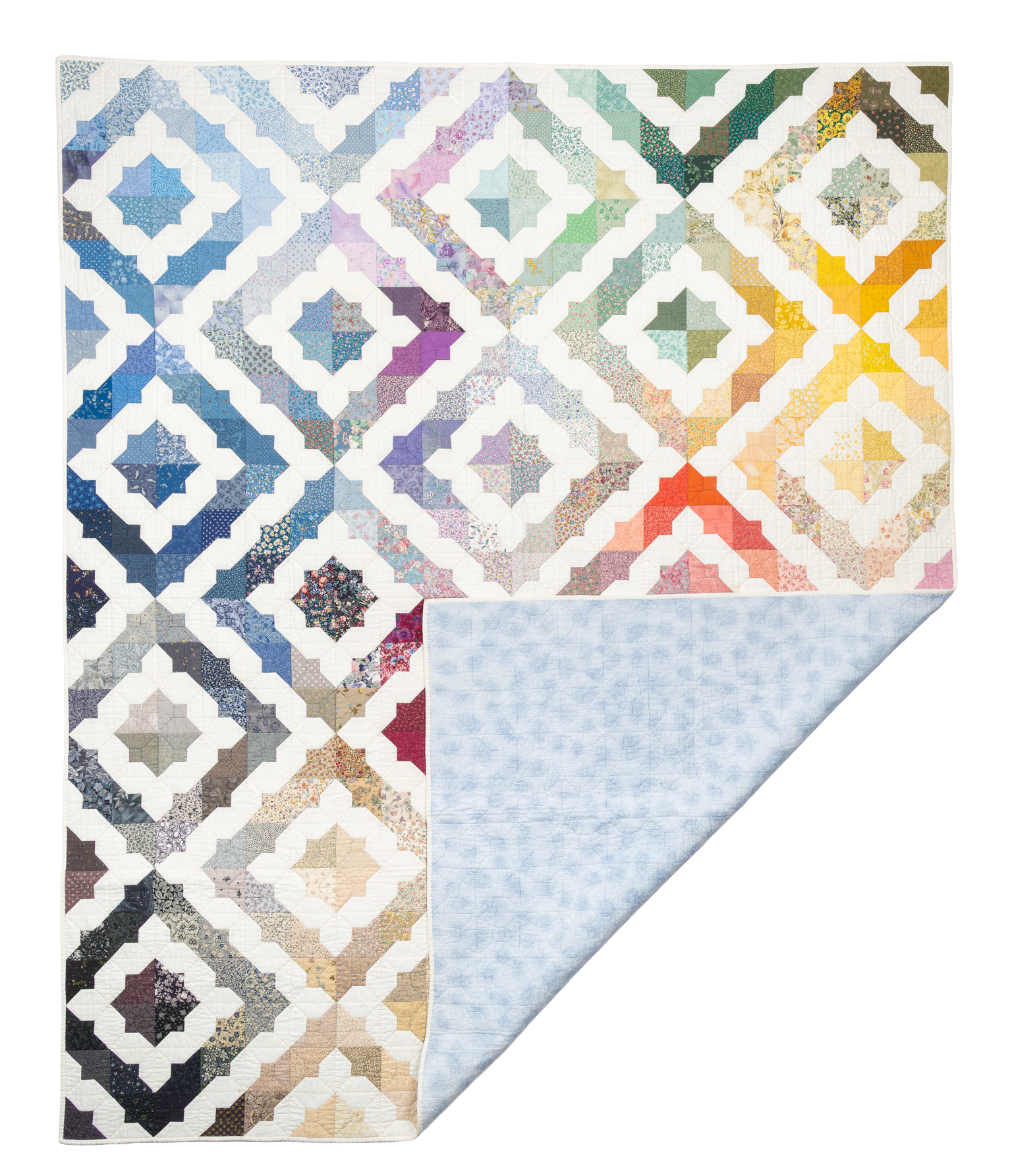 Colors, a multicolor diamond-repeat quilt photographed flat with a pale blue backing corner folded open.
