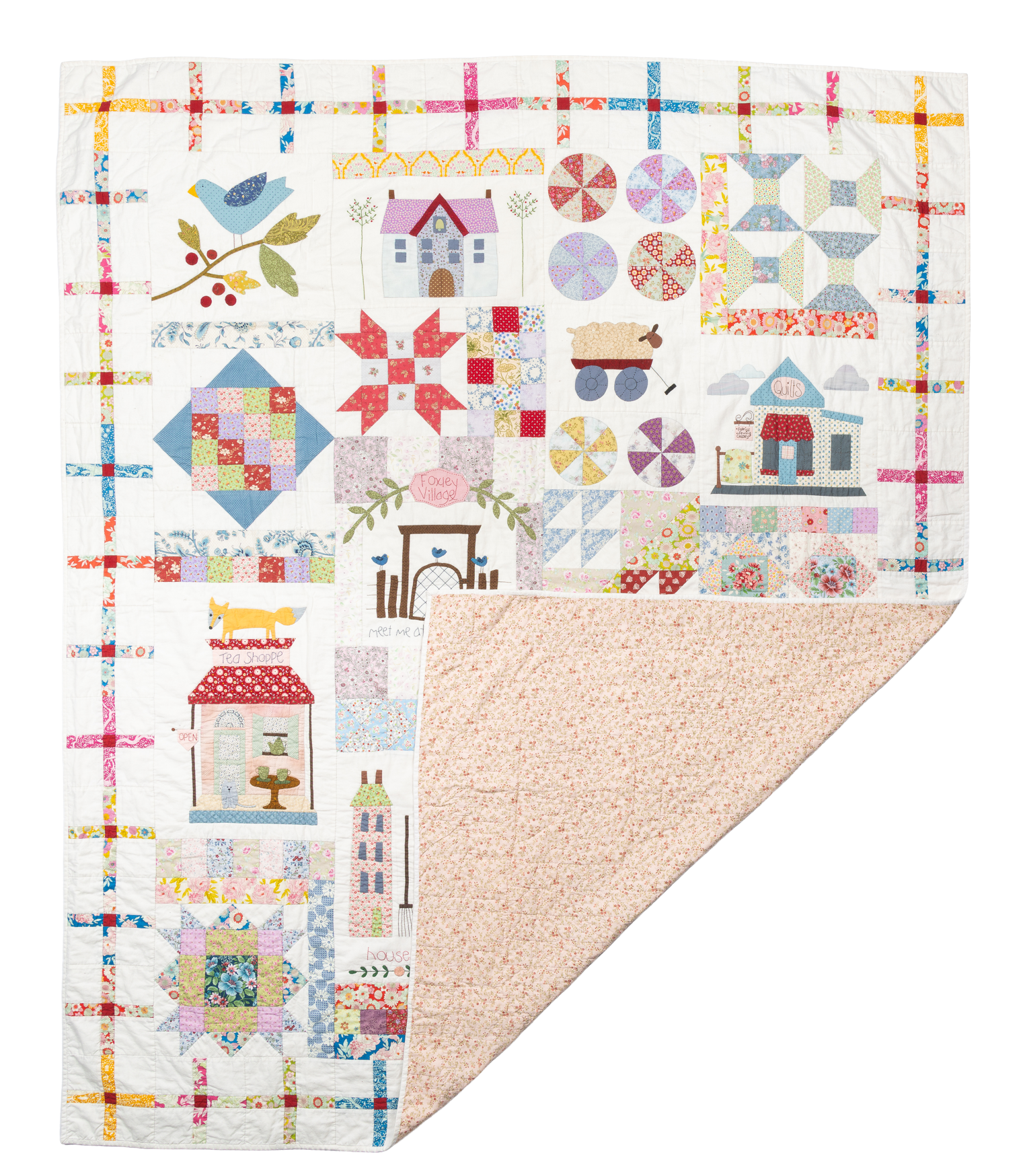 Foxley Village, a colorful house and village quilt with the name appliquéd onto the surface.
