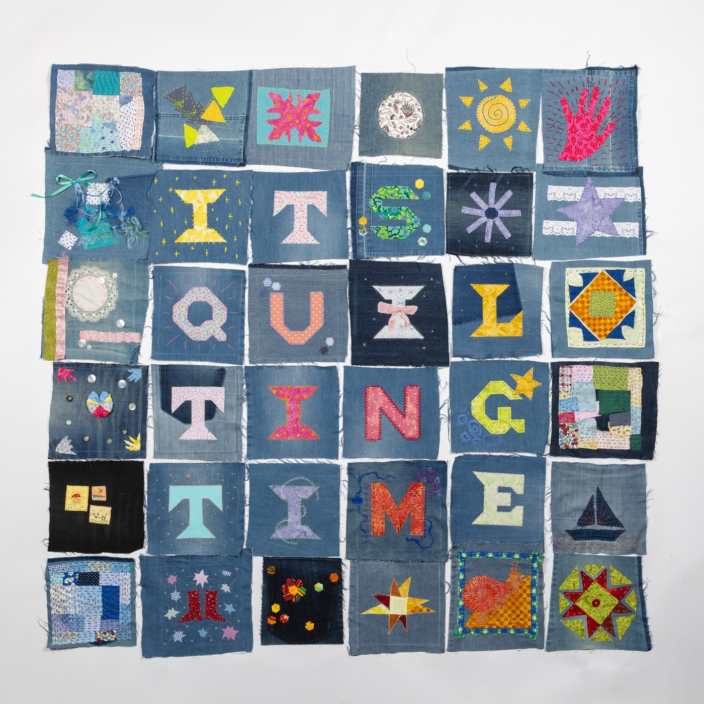 Community quilt blocks arranged edge to edge in a grid, not yet sashed or quilted together.