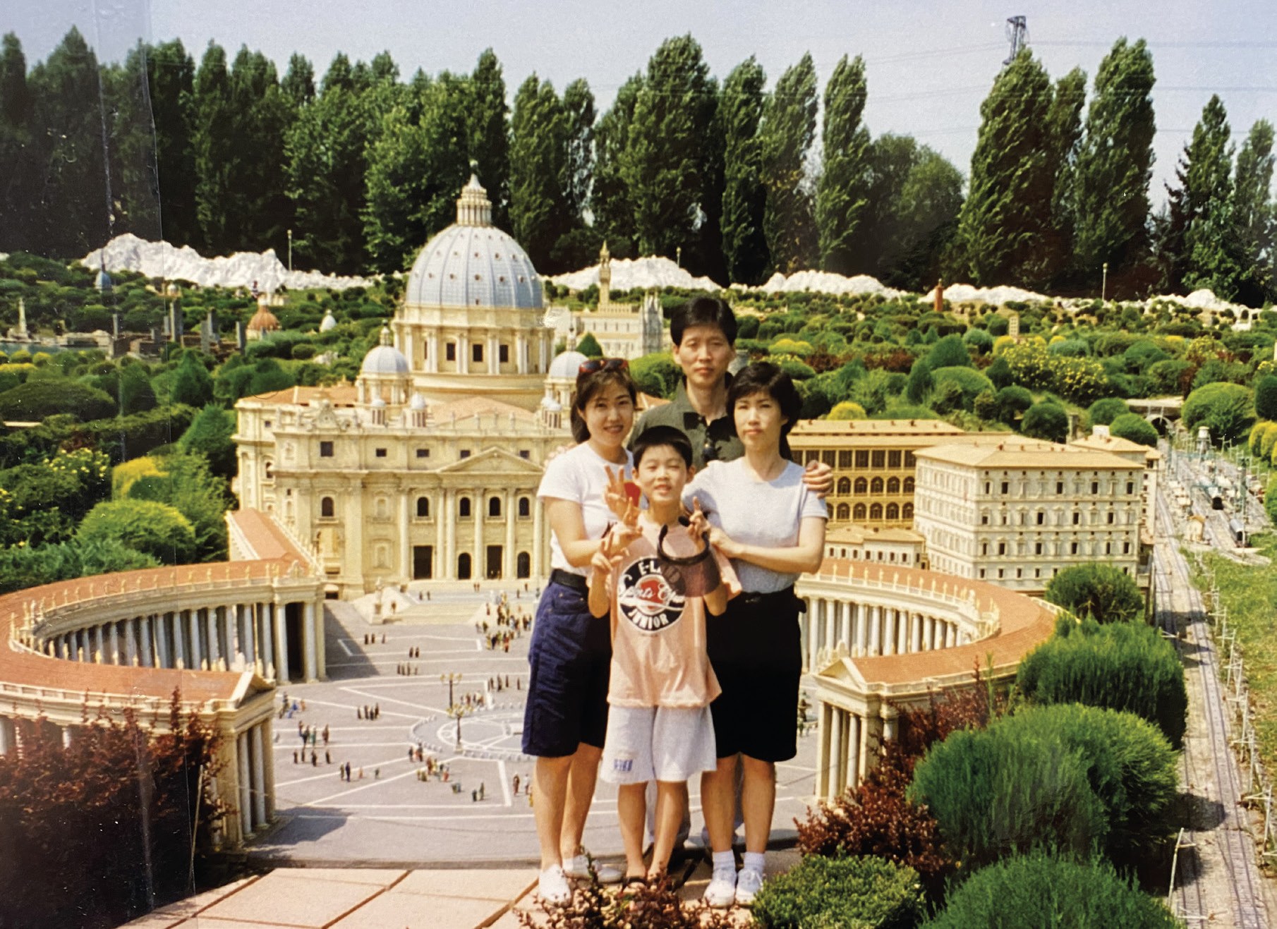 An old family photograph of four people posing in front of a miniature model of St. Peter's Basilica during a trip to Italy.